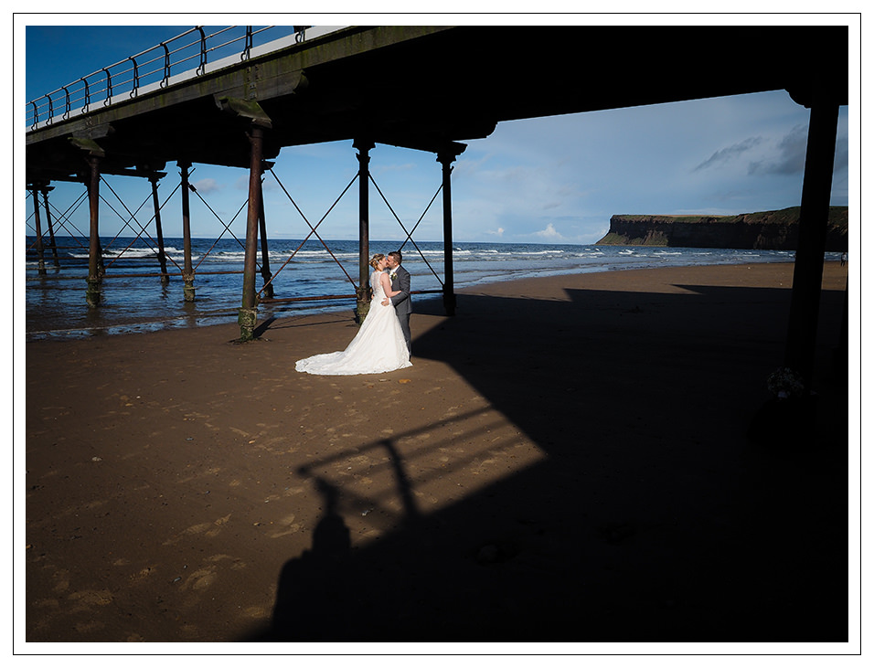on the beach at saltburn for a bride and groom portrait