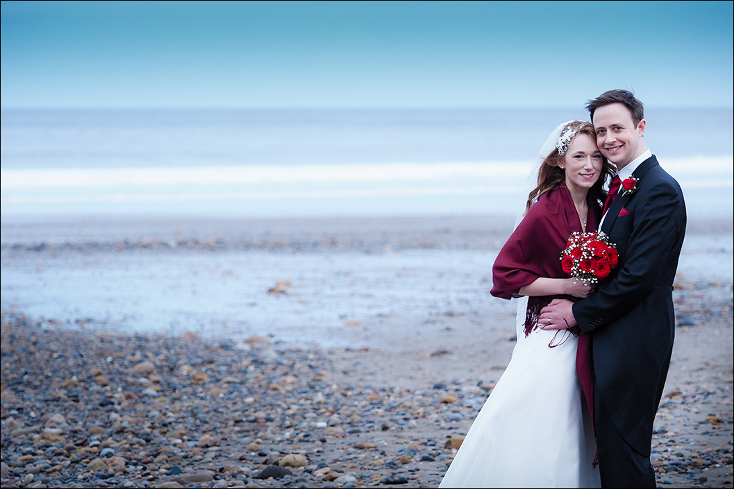 bride and groom portrait on sandsend beach on a cold january day