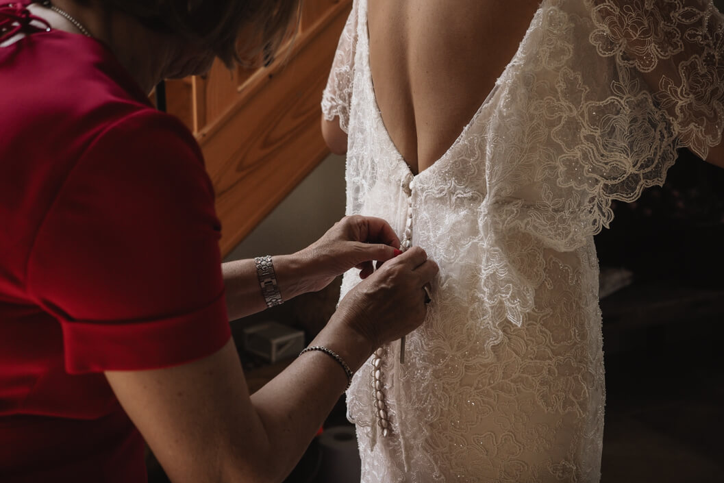 bride having the finishing touches to her dress at crossbutts stables, whitby