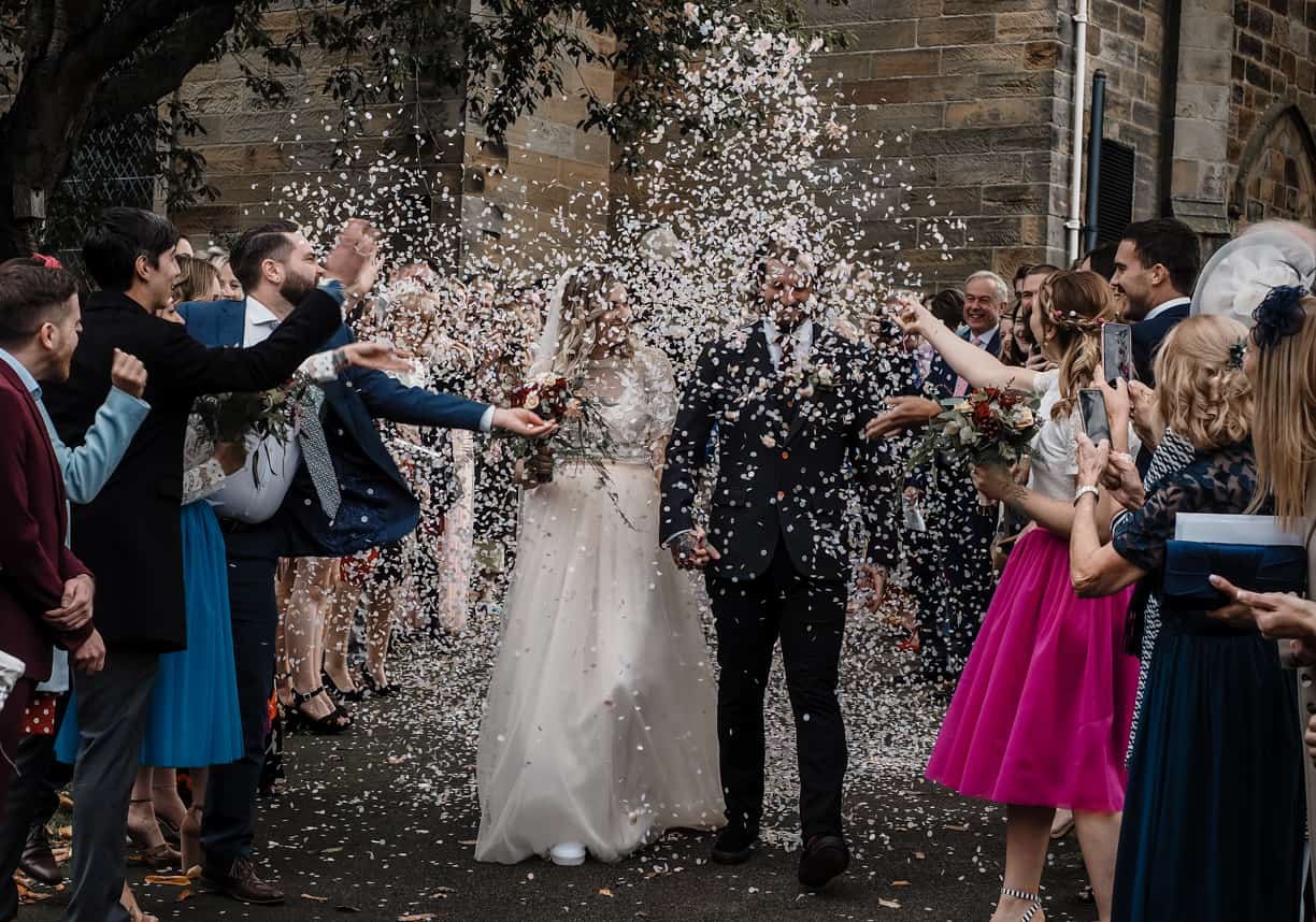 bride and groom showered in confetti at their north yorkshire wedding
