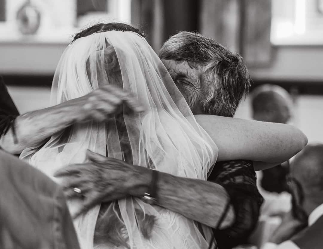 bride receiving a hug and congratulations from her granmother after the wedding ceremony